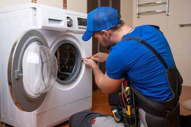 Appliance repair professional servicing a residential washing machine