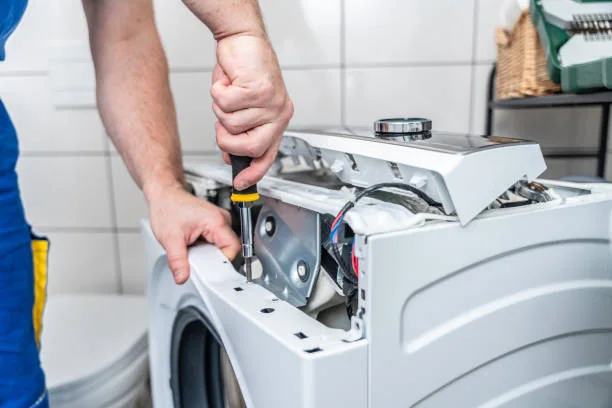 Technician completing diagnostic work on a household washing machine