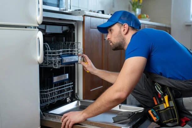 Technician inspecting the interior of a residential dishwasher