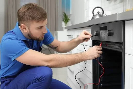 Technician testing an oven control panel with diagnostic leads