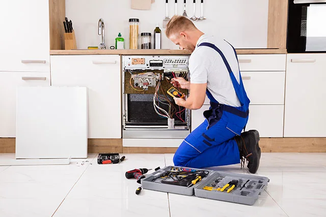 Technician diagnosing the internal components of a residential range