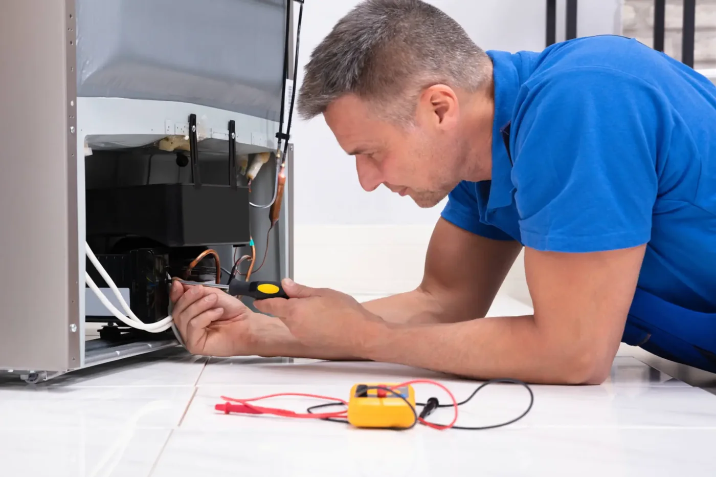 Technician repairing the cooling system of a refrigerator