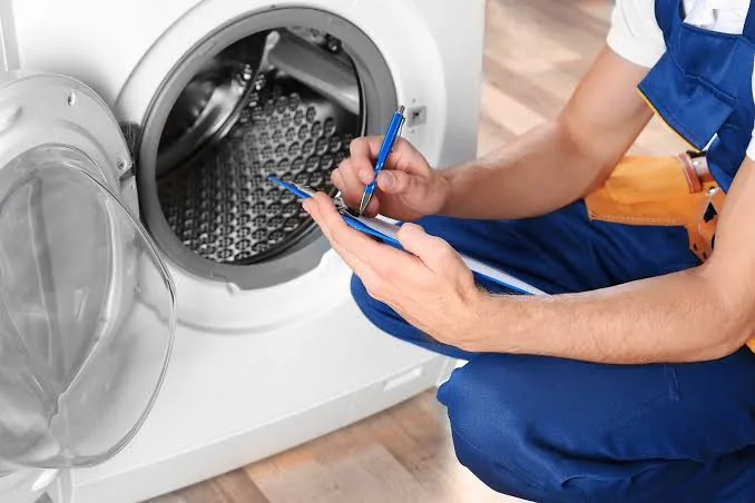 Technician documenting a front-loading washer repair